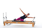 <p><strong>Setup</strong></p><ul><li><p>Sitting sideways on carriage, one leg bent against shoulder rests, other leg bent in front of body, arms straight, one hand placed on footbar in line with shoulder, other arm down by side</p></li><li><p>Resistance: light | <strong>Springs:&nbsp;1R</strong></p></li></ul><p><strong>Movement</strong></p><ul><li><p>Inhale: Push carriage out, lower body until arm is parallel with floor, simultaneously lift other arm to diagonal line</p></li><li><p>Exhale: Rotate trunk, bring arm around to footbar</p></li><li><p>Inhale: Rotate trunk back to previous position</p></li><li><p>Exhale: Bring carriage in, return to start position</p></li></ul><p><strong>Muscle Focus</strong></p><ul><li><p>Spinal lateral flexors</p></li><li><p>Spinal rotators</p></li><li><p>Spinal extensors</p></li><li><p>Shoulder abductors</p></li></ul><p><strong>Objectives</strong></p><ul><li><p>Spinal lateral flexor and rotator control</p></li><li><p>Spinal mobility</p></li><li><p>Shoulder abductor control</p></li></ul><p><strong>Cues</strong></p><ul><li><p>Keep both arms straight</p></li><li><p>Pivot around supporting shoulder during rotation</p></li></ul><p></p>