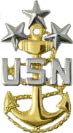 <p>Gold fouled anchor with silver USN centered across the anchor below three silver stars</p>