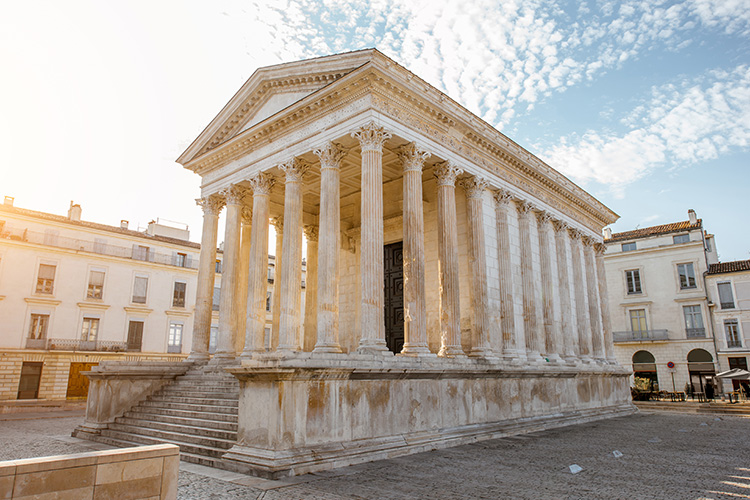 <p>Welke typische Romeinse kenmerken heeft de Maison Carrée?</p>