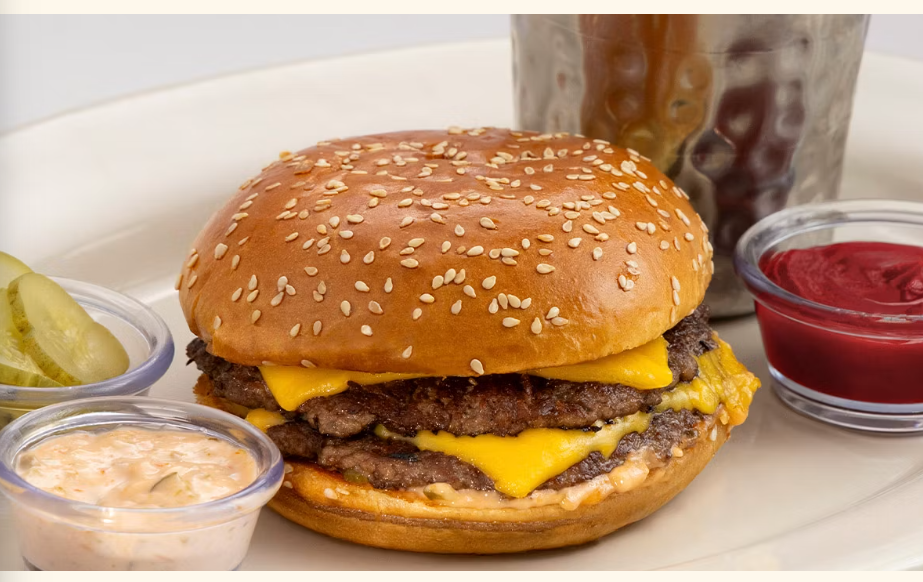 <p>Double Patties, Double Cheese, Grilled Onions and Special Sauce on a Toasted Brioche Roll. Served with French Fries or Green Salad</p>