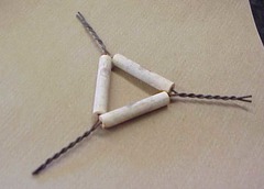 <p>wire frame with porcelain supports; used to support a crucible</p>
