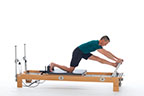 <p><strong>Setup</strong></p><ul><li><p>Kneeling on carriage, one foot on footbar, knee over ankle, other foot against shoulder rest, knee on carriage, arms straight, hands placed on footbar, shoulder width apart</p></li><li><p>Resistance: light | <strong>Springs:&nbsp; 1R</strong></p></li></ul><p><strong>Movement</strong></p><ul><li><p>Inhale: Stretch hip flexors of leg on carriage (3-5 breaths)</p></li><li><p>Exhale: Straighten front leg, lower trunk forward (3-5 breathes)</p></li><li><p>Inhale: Bend leg, return to start position</p></li><li><p>Change sides after 2 repetitions</p></li></ul><p><strong>Muscle Focus</strong></p><ul><li><p>Hip flexors</p></li><li><p>Hip extensors</p></li></ul><p><strong>Objectives</strong></p><ul><li><p>Hip flexor stretch</p></li><li><p>Hip extensor stretch</p></li></ul><p><strong>Cues</strong></p><ul><li><p>Bias toward posterior tilt of pelvis during hip flexor stretch</p></li><li><p>Bias toward anterior tilt of pelvis during hamstring stretch</p></li><li><p>Move pelvis along horizontal line when straightening and bending front leg</p></li><li><p>Maintain spinal extensor engagement during hamstring stretch</p></li></ul><p></p>