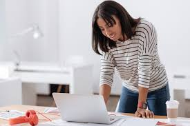 <p>The woman is leaning over the table.</p>