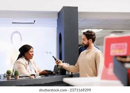 <p>The man is standing at the checkout counter.</p>