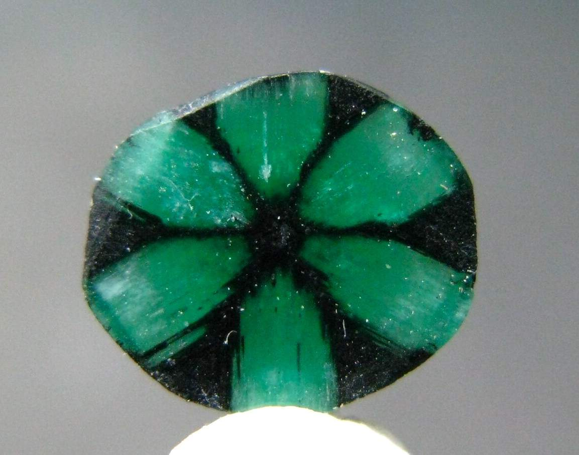 <p><strong>Trapiche emeralds</strong> are rare gemstones characterized by a six-spoke radial pattern resembling a traditional Colombian grinding wheel.</p><p><strong>What causes this distinctive pattern?</strong></p>