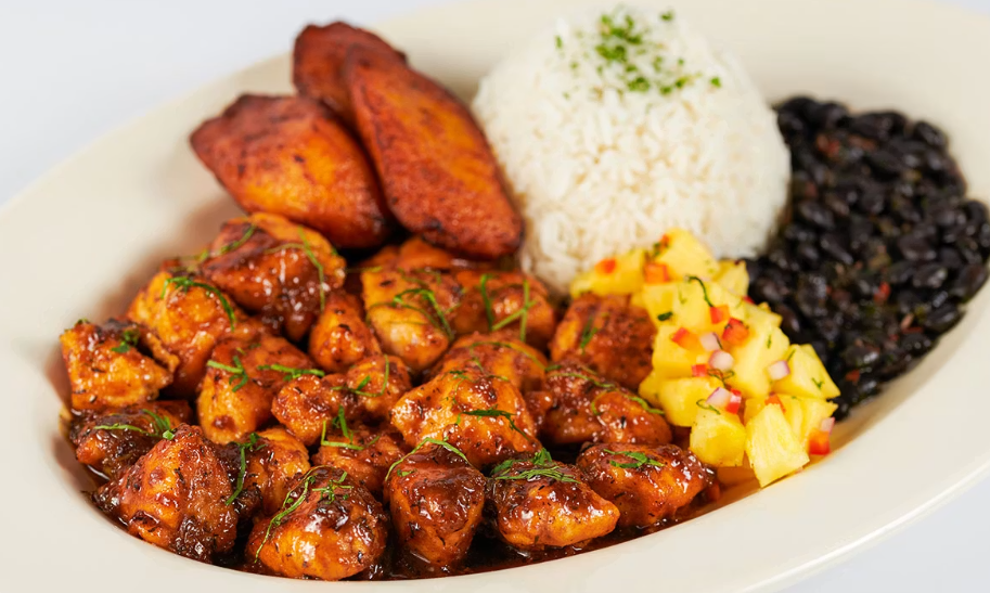 <p>Sauteed Chicken with a Very Spicy Jamaican Black Pepper Sauce. Served with Rice, Black Beans, Plantains and Marinated Pineapple</p>