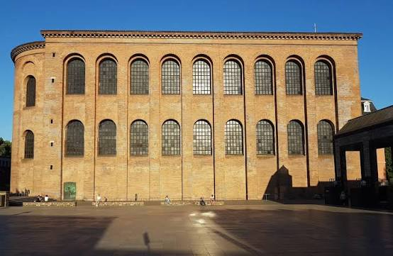 <p>Op de maquette van Trier zie je centraal de Basilica, als onderdeel van het grote paleis van keizer Constantijn I.</p><p>Welke typische kenmerken van de Romeinse bouwstijl en bouw materialen herken je in dit imposante gebouw?</p>