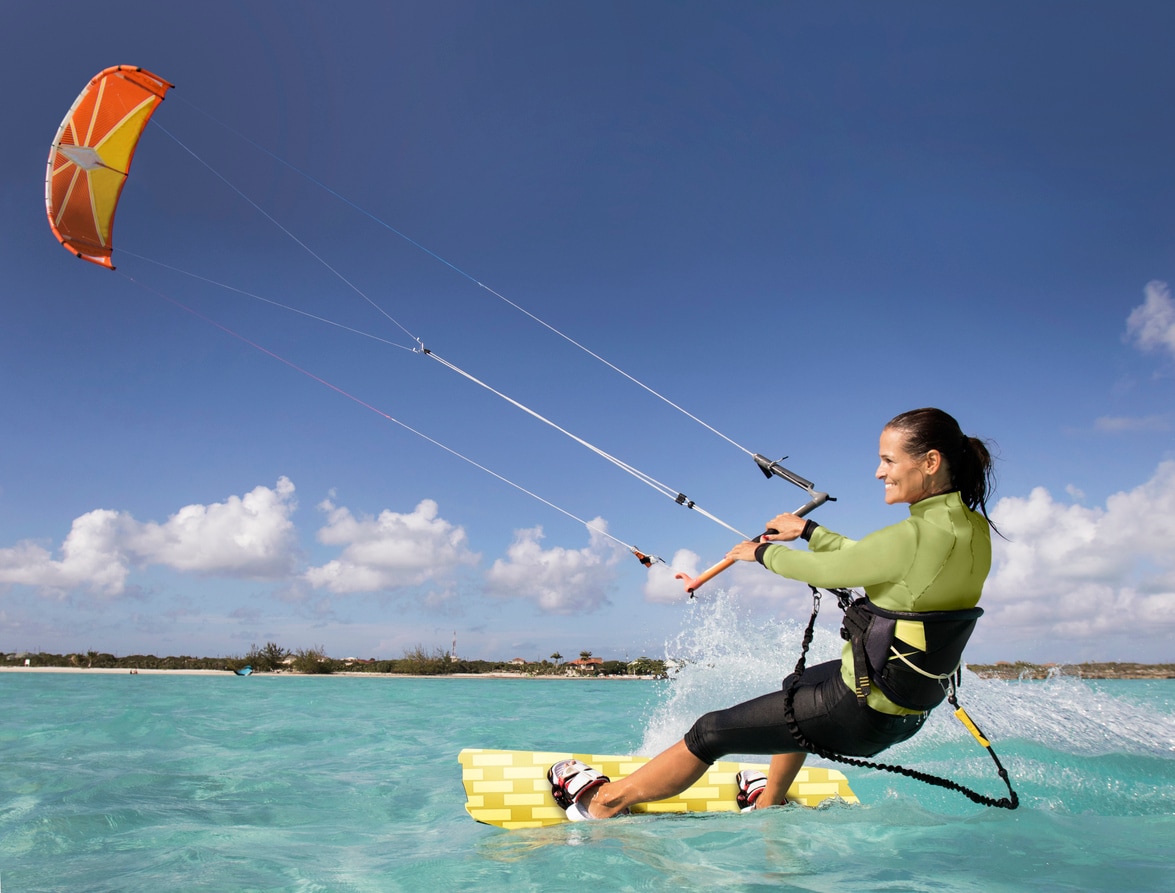 <p>Surfing while being pulled by a kite(воздушный змей)</p>