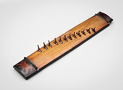 <ul><li><p>(Chordophone) zither-like plucked instrument.</p></li></ul><p></p>