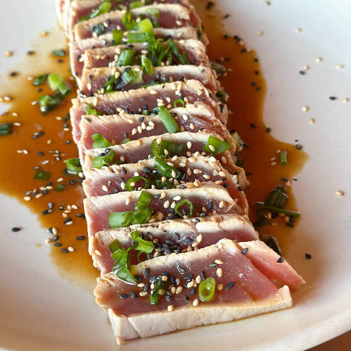 <p>Ponzu , scallions , pan fried garlic, siracha (the tuna is bordered w sesame seeds)</p>