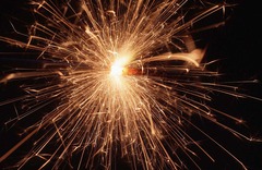 <p>The transfer of electrons between two surfaces that have an imbalance of charges. Sparking can be particularly dangerous in locations such as petrol pumps, and so the pumps must be earthed.</p>