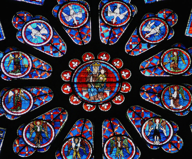 <p><span><strong>Rose Windows</strong></span></p><p></p><p>the star of Chartres' large rose window is the Virgin Mary. A rose window is the immense circular shaped windows you find in Gothic-era churches, and much like a flower in full bloom, it radiates out from a central focus.</p><p>The one at Chatres is an incredible <strong>43' in diameter</strong>. Along with the peaked rectangular windows below called <strong>lancets,</strong> this rose window was a gift from the Queen Blanche of Castile, mother of French King, Louis IX (. There are eight windows below the rose featuring the royal motifs of yellow castles on red ground (the arms of Castile) and yellow <strong><em>fleurs-di-lis,</em> </strong>the lily flowers with three petals that is France’s royal emblem (image #2 below).</p>