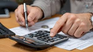 <p>The man is using a calculator.</p>