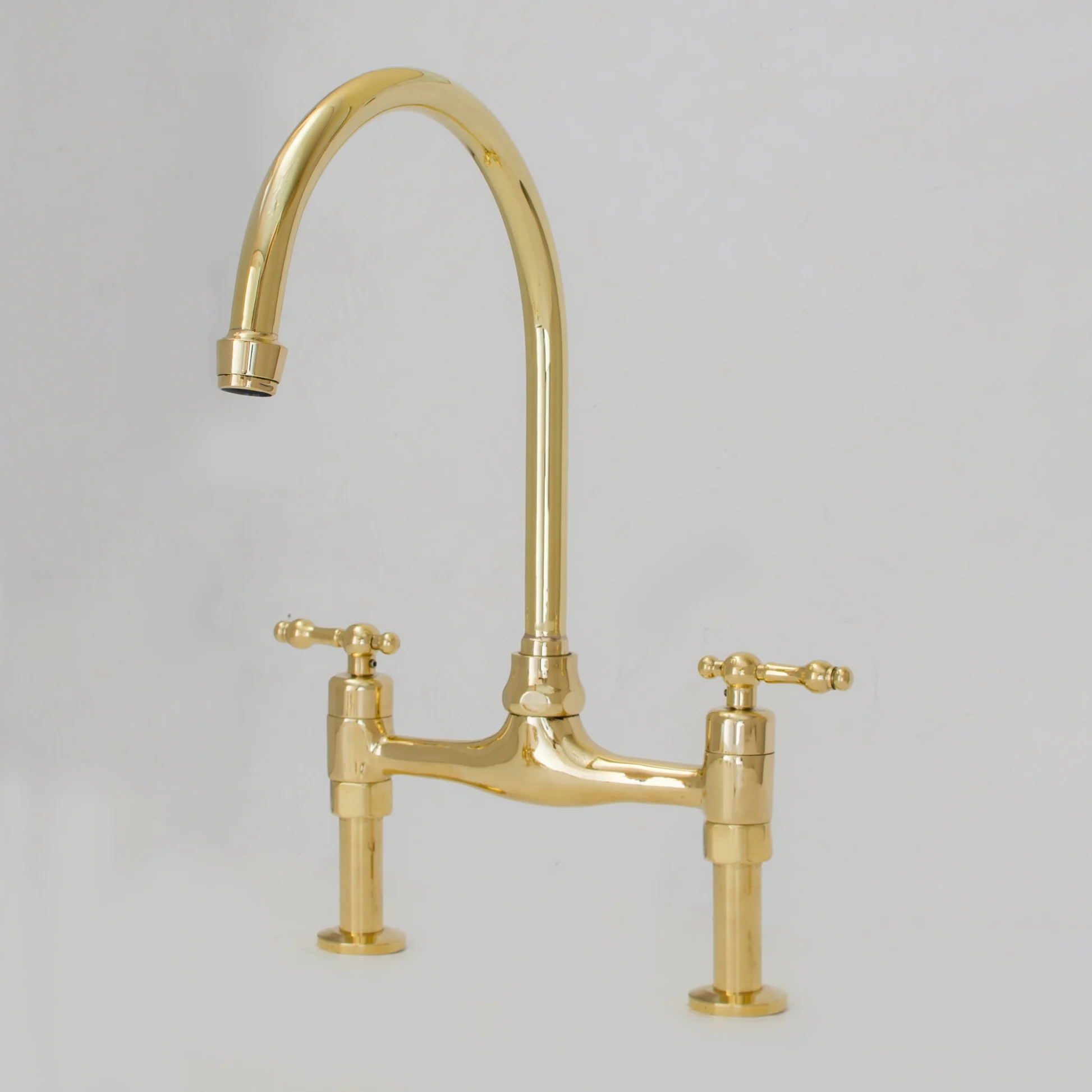 <p>• A faucet with <strong>two separate handles (hot and cold)</strong> connected by an <strong>exposed horizontal bridge</strong> above the sink.</p><p><span data-name="point_right" data-type="emoji">👉</span> Think: <strong>“The hot and cold water lines are connected by a visible bridge.”</strong></p><p>Unlike modern concealed faucets, the connecting pipe remains visible, giving it a classic or vintage appearance.</p><p><span data-name="warning" data-type="emoji">⚠</span> <strong>ALE Trap:</strong><br><strong>Bridge Faucet</strong> refers to the <strong>design or configuration</strong> of the faucet—not necessarily its internal operating mechanism. A bridge faucet may use <strong>compression, cartridge, or ceramic disk valves</strong>.</p><p></p><p><span data-name="gear" data-type="emoji">⚙</span><strong> Main Components</strong></p><p><strong>Bridge Pipe</strong></p><ul><li><p>Exposed horizontal pipe connecting hot and cold supplies</p></li><li><p>Gives the faucet its distinctive appearance</p></li></ul><p><strong>Two Handles</strong></p><ul><li><p>One for hot water</p></li><li><p>One for cold water</p></li></ul><p><strong>Spout</strong></p><ul><li><p>Usually centered between the handles</p></li><li><p>Often available in gooseneck or high-arc designs</p></li></ul><p><strong>Valve Mechanism</strong></p><ul><li><p>May use:</p><ul><li><p>Compression valves</p></li><li><p>Cartridge valves</p></li><li><p>Ceramic disk valves</p></li></ul></li></ul><p></p><p><span data-name="house" data-type="emoji">🏠</span><strong> Common Uses</strong></p><p><span data-name="check_mark_button" data-type="emoji">✅</span> Traditional kitchens</p><p><span data-name="check_mark_button" data-type="emoji">✅</span> Farmhouse kitchens</p><p><span data-name="check_mark_button" data-type="emoji">✅</span> Vintage or classic homes</p><p><span data-name="check_mark_button" data-type="emoji">✅</span> Luxury residential bathrooms</p><p><span data-name="check_mark_button" data-type="emoji">✅</span> Decorative plumbing installations</p><p></p><p><span data-name="bullseye" data-type="emoji">🎯</span><strong> Main Purpose</strong></p><ul><li><p>Provides independent hot and cold water control</p></li><li><p>Adds a decorative or traditional appearance</p></li><li><p>Combines aesthetics with functionality</p></li></ul><p></p><p><span data-name="check_mark_button" data-type="emoji">✅</span><strong> Advantages</strong></p><ul><li><p>Elegant, timeless appearance</p></li><li><p>Durable construction (often brass or stainless steel)</p></li><li><p>Separate control of hot and cold water</p></li><li><p>Available with modern leak-resistant valve mechanisms</p></li></ul><p></p><p><span data-name="cross_mark" data-type="emoji">❌</span><strong> Disadvantages</strong></p><ul><li><p>Requires more sink or countertop space</p></li><li><p>Installation is more complex than many single-hole faucets</p></li><li><p>Usually more expensive than standard faucets</p></li></ul><p></p>
