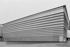 <p>het gebouw is een voorbeeld van tektonisch bouwen maar straalt wel veel zwaarte en massa uit. dit is omdat het gebouw laat zien van buiten wat er binnenin gebeurt. (opslagplaats, stapeling) de gevel is structureel niet nodig en draagt enkel bij aan het karakter van het gebouw en het licht tegen te houden.</p>