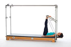 <p><strong>Setup</strong></p><ul><li><p>Lying supine, heels placed on PTBar hip width apart, legs bent</p></li><li><p>Resistance: medium to heavy <strong>[bottom loaded] 2 springs + safety belt</strong></p></li></ul><p><strong>Movement</strong></p><ul><li><p>Exhale: Straighten legs</p></li><li><p>Inhale: Bend legs, return to start position</p></li></ul><p><strong>Muscle Focus</strong></p><ul><li><p>Hip extensors</p></li><li><p>Knee extensors</p></li></ul><p><strong>Objectives</strong></p><ul><li><p>Hip extensor strength</p></li><li><p>Knee extensor control</p></li><li><p>Foot alignment and stabilization</p></li><li><p>Pelvic lumbar stabilization</p></li></ul><p><strong>Cues</strong></p><ul><li><p>Maintain hip extensor engagement</p></li><li><p>Keep feet dorsiflexed and stable as if standing on floor</p></li><li><p>Reach heels toward ceiling when straightening legs</p></li><li><p>Maintain pelvic lumbar stabilization</p></li><li><p>Avoid excessive knee flexion (maximum 90 degrees)</p></li><li><p>Straighten legs completely, avoiding hyperextension</p></li></ul><p></p>