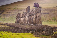 <p>The image shows several large stone Moai figures standing on a stone platform (ahu), looking inland. Which explanation best reflects current scholarly understanding of their cultural role?</p>