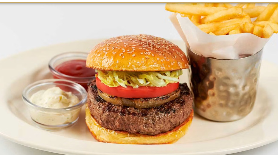 <p>A Chop House Hamburger. Topped with a Slice of Grilled Onion, Lettuce and Tomato</p>