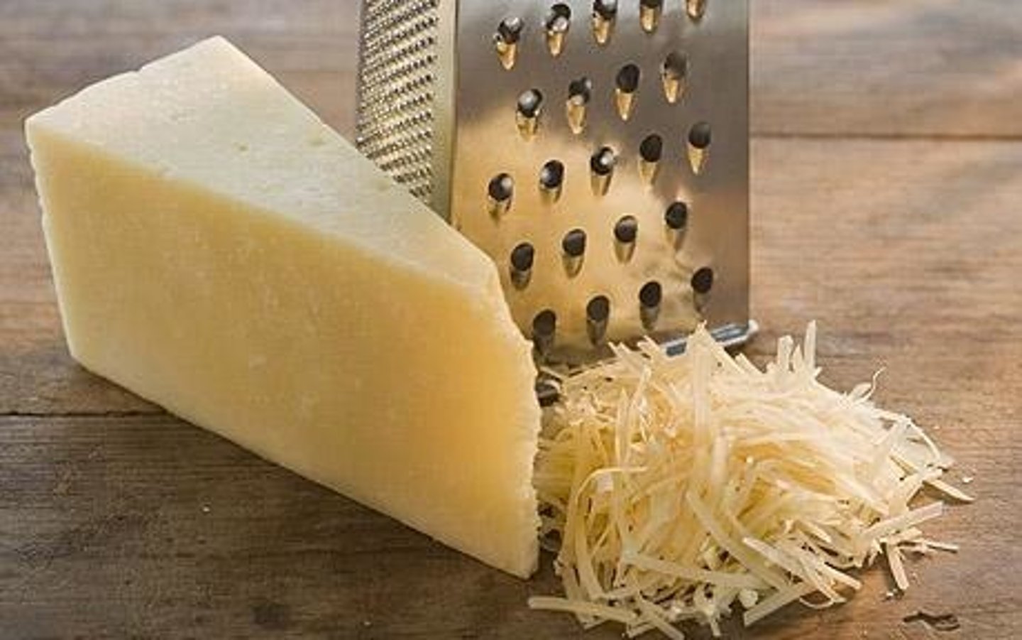 <p>to shred or cut down a food into fine pieces by rubbing it against a rough surface</p>