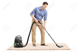 <p>The man is vacuuming the carpet.</p>