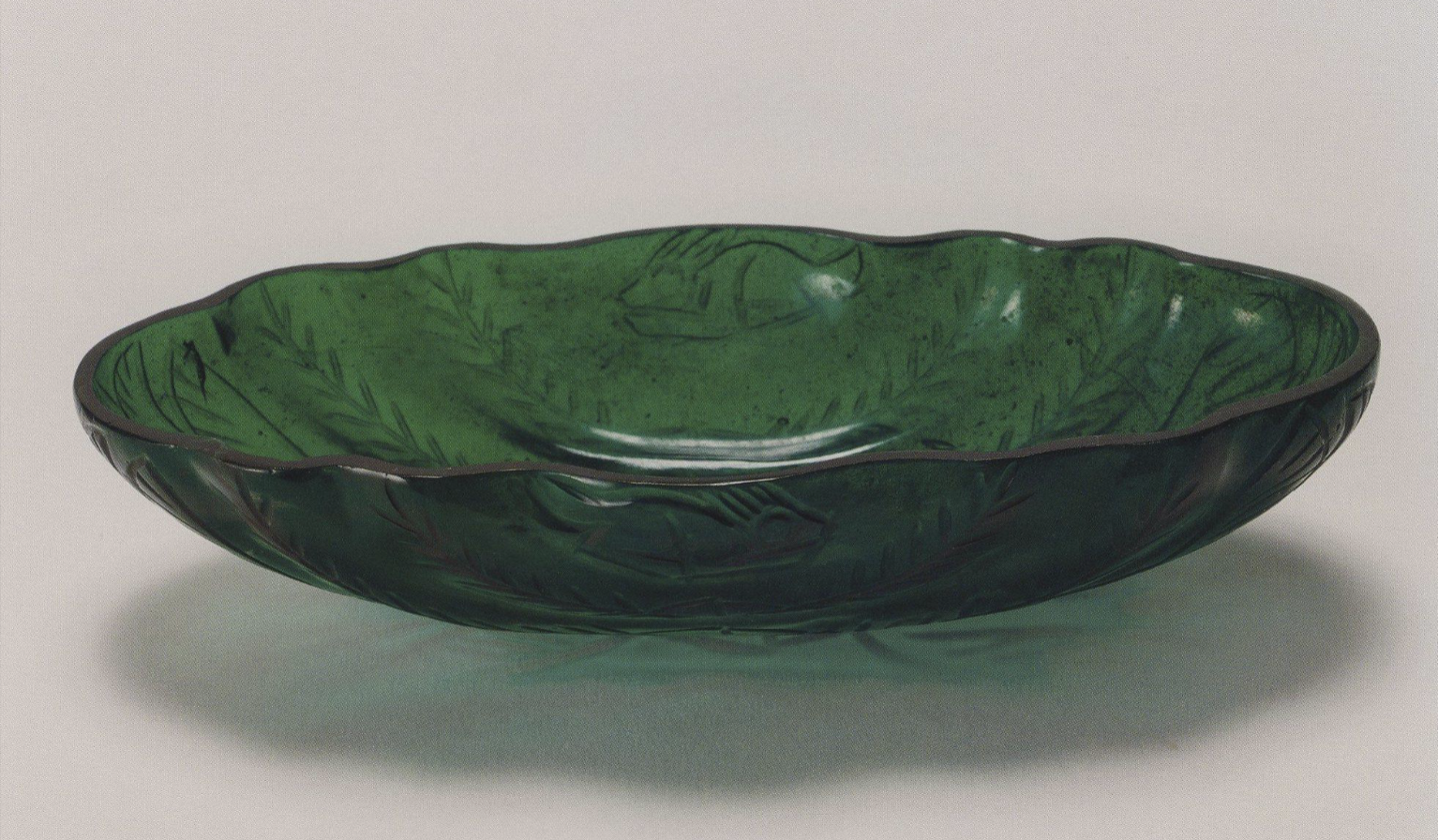 <p>12-lobed oblong cup of green glass</p>