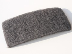 <p>Rough, suitable for grinding or polishing (such as sandpaper); causing irritation or annoyance</p>