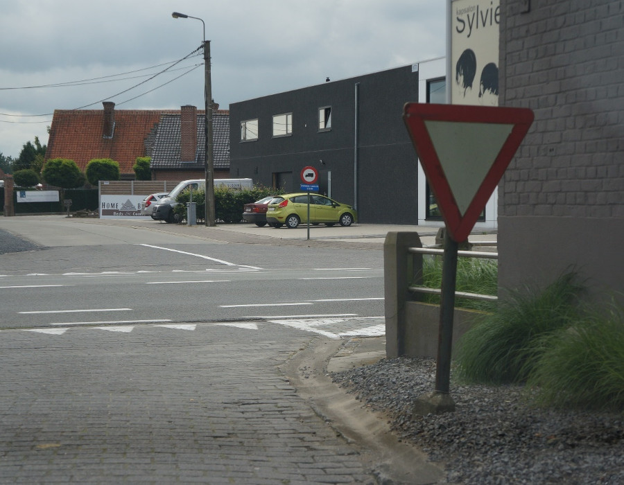 <p><br><span>Wat duiden de witte driehoeken op de grond aan?</span></p><ul><li><p>De plaats waar bestuurders moeten stoppen om voorrang aan rechts te verlenen.</p></li><li><p>De plaats waar bestuurders voorrang verlenen en indien nodig stoppen.</p></li></ul><p></p>