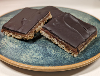 <p>Chewy coconut, oatmeal cookie base, covered in a caramel-like layer made of dates and sunflower seed butter, topped with chocolate ganache. Vegan!</p>