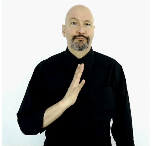 <p>dom hand holds out five and places thumb on chest</p>
