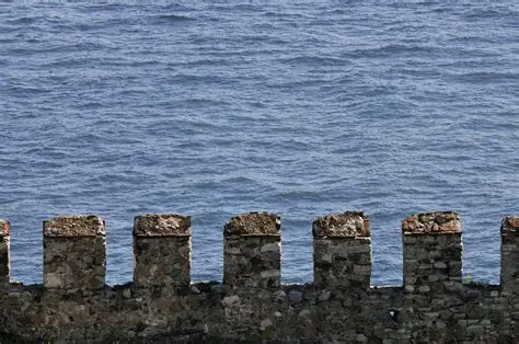 <p><span style="background-color: transparent;">A sequence of solid parts, and the intervals between them, along the top of a parapet, allowing for defense and to facilitate firing weapons. The effect is of a notched termination of a wall. Generally used in military architecture.</span></p>