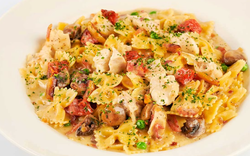 <p>Bow-Tie Pasta, Chicken, Mushrooms, Tomato, Pancetta, Peas and Caramelized Onions in a Roasted Garlic-Parmesan Cream Sauce</p>