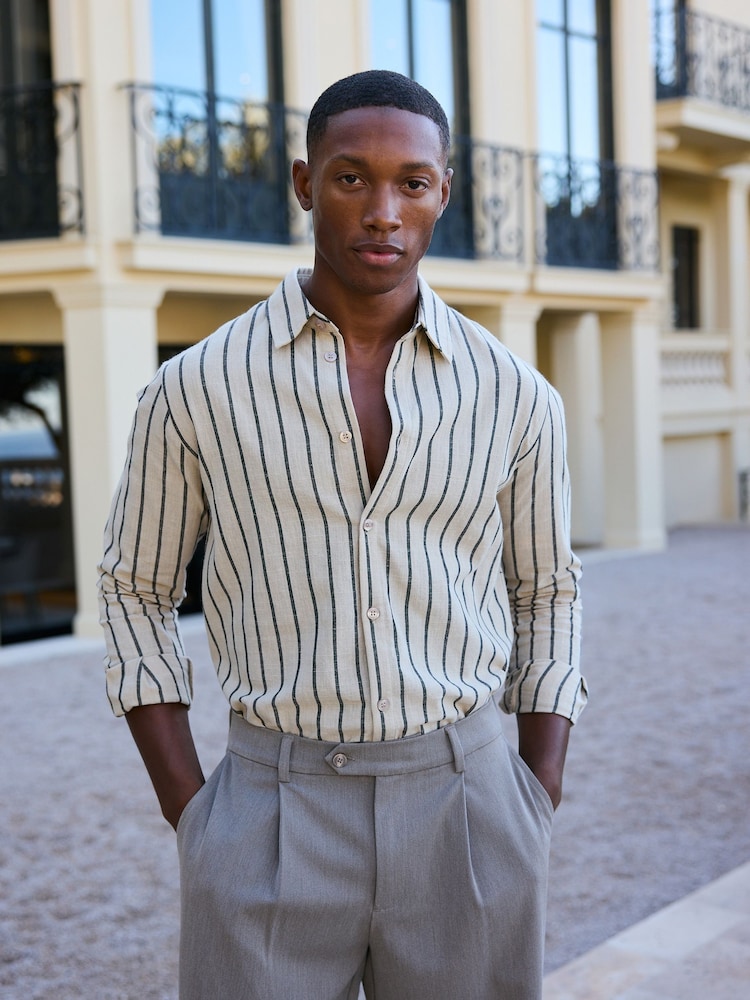 <p>He is wearing a <strong>striped shirt</strong>.</p>