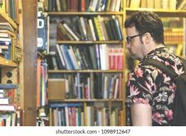 <p>The man is browsing in the bookstore.</p>