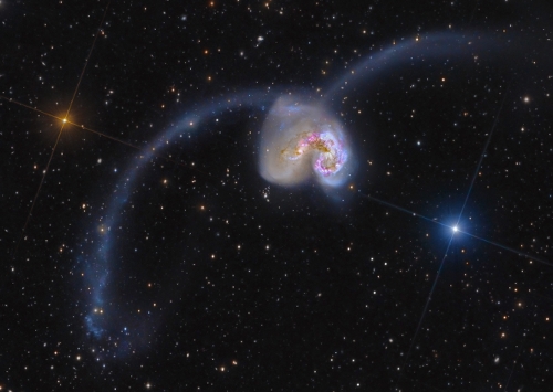 <p>Consider the galaxy in this photograph.&nbsp; How did the galaxy get its shape?</p><p>A. <span>A large burst of supernova explosions distorted an elliptical galaxy into this shape.</span></p><p><span>B. This is the product of the dynamic merger of two spiral galaxies.</span></p><p><span>C. This galaxy was created with the shape it has.</span></p><p><span>D. This was originally an elliptical galaxy, but a near encounter with a small irregular galaxy perturbed it into this shape.</span></p>