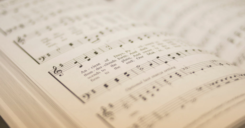 <p>A religious song or poem of praise to God, often shown with an image of a church or congregation singing.</p>