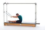 <p><strong>Setup</strong></p><ul><li><p>Start sitting upright in the middle of the Cadillac, pelvis lined up with the center F2 plate, crossbar at #24, legs straight and together, feet plantarflexed, hands holding RUBar, arms straight and shoulder width apart, round trunk into C Curve</p></li><li><p>Resistance: light to medium<strong> [Heigh of bar at eye level when sitting in the Cadillac] </strong><br><strong>You need tension on the springs</strong></p></li></ul><p><strong>Movement</strong></p><ul><li><p>Exhale: Roll down to neutral spine position</p></li><li><p>Inhale: Lift head and chest</p></li><li><p>Exhale: Roll up, return to start position</p></li><li><p>Inhale: Pause</p></li></ul><p><strong>Muscle Focus</strong></p><ul><li><p>Spinal flexors</p></li><li><p>Spinal extensors</p></li></ul><p><strong>Objectives</strong></p><ul><li><p>Spinal flexor control</p></li><li><p>Spinal extensor control</p></li><li><p>Trunk stabilization</p></li></ul><p><strong>Cues</strong></p><ul><li><p>Maintain C curve position when rolling down and rolling up</p></li><li><p>Pause when shoulders are in front hip joints and eyes over knee joints</p></li><li><p>Keep head aligned with spine</p></li><li><p>Maintain scapular stabilization</p></li></ul><p></p>
