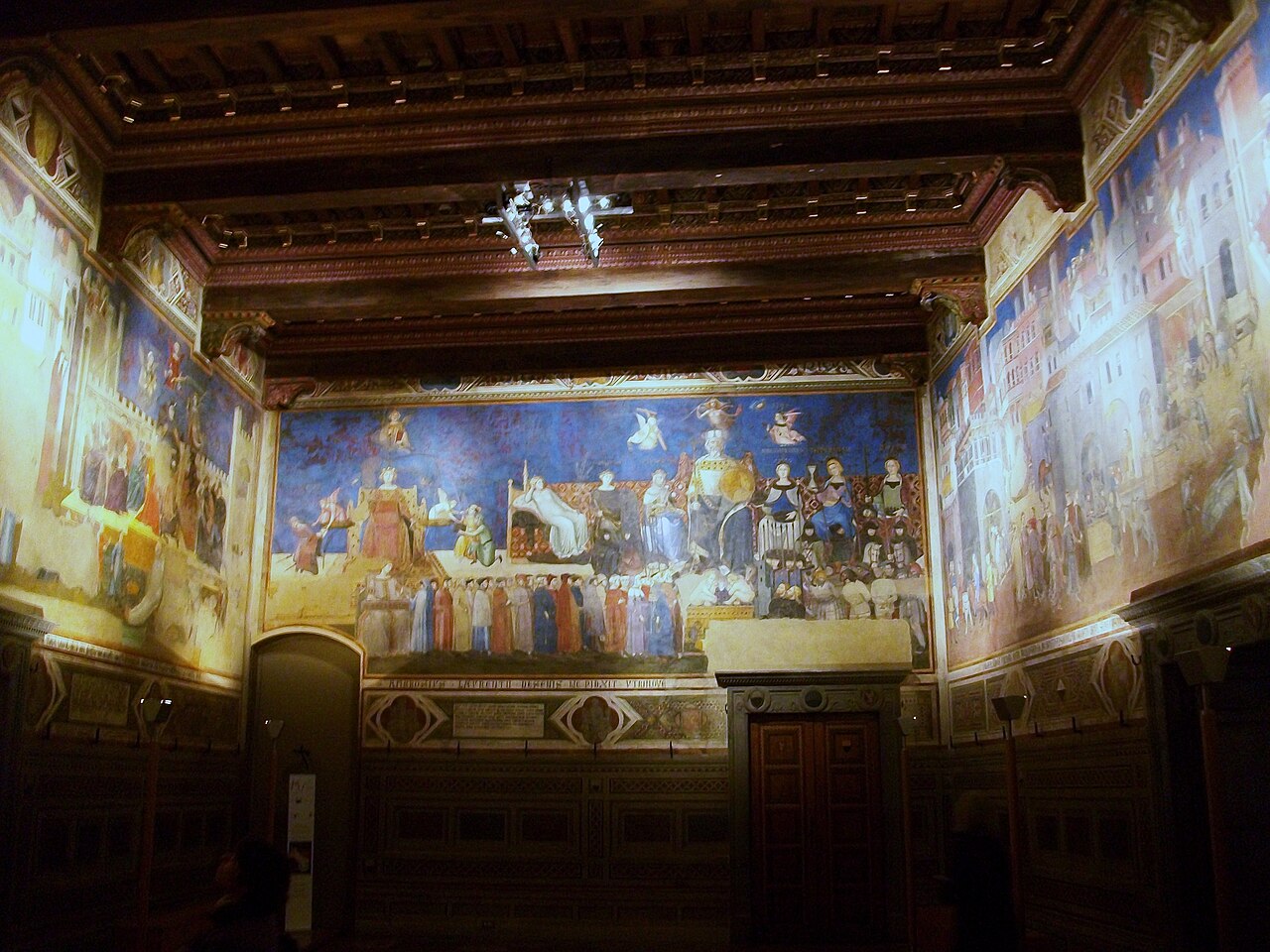 <ul><li><p>Cycle of Six Frescoes that were / are immediately appealing for their robust naturalism which contrasts with the overworked Byzantine style of the namesake painter’s predecessors, or the strongly derivative style of some of his contemporaries</p><ul><li><p>The namesake artist was widely acclaimed for these magnificent frescoes commissioned by the city government of Siena to decorate the council chamber of its headquarters, the Palazzo Pubblico </p></li></ul></li><li><p>The part of the mural showing the effects of good government depicts everyday life in a peaceful city, Siena, with merchants, builders, peasants, and other citizens going about their everyday business under the eye of the allegorical figure of Security, one of the first female nudes in Christian art</p><ul><li><p>The figure of Justice will remind the city fathers who use the chamber of the chief role of government, along with the Common Good and Virtues</p></li><li><p>Various essential skills and professions are also depicted, such as weaving, agriculture, trade, and metalworking</p></li></ul></li></ul><p></p>