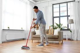 <p>The man is sweeping the floor.</p>