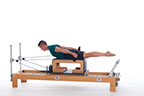 <p><strong>Setup</strong></p><ul><li><p>Lying prone on Long Box, neutral spine position, legs straight and together, parallel to floor, feet plantarflexed toward footbar, arms straight, forward of shoulders, hands holding folded straps, palms facing each other</p></li><li><p>Resistance: light | <strong>Springs: 1B or 1R</strong></p></li></ul><p><strong>Movement</strong></p><ul><li><p>Inhale: Lift trunk, move arms back to sides of body</p></li><li><p>Exhale: Lower trunk, move arms forward, return to start position</p></li></ul><p><strong>Muscle Focus</strong></p><ul><li><p>Spinal extensors</p></li><li><p>Hip extensors</p></li><li><p>Shoulder extensors</p></li></ul><p><strong>Objectives</strong></p><ul><li><p>Spinal extensor strength</p></li><li><p>Hip extensor control</p></li><li><p>Shoulder extensor control</p></li></ul><p><strong>Cues</strong></p><ul><li><p>Keep palms facing each other</p></li><li><p>Initiate movement with back extensors</p></li><li><p>Articulate spine into extension starting from crown of head</p></li><li><p>Bring arms forward of shoulder line no more than 20 degrees</p></li><li><p>Keep legs parallel to floor</p></li></ul><p></p>
