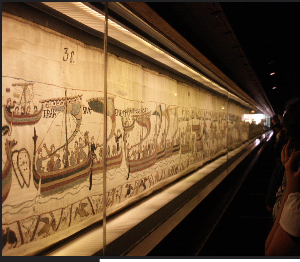 <p><strong>Bayeux Tapestry</strong><span> on display--Normans sailing across the English Channel</span></p><p><span>-Using cloth, needle, and thread,</span></p><p><span>-an enormous continuous, scroll-like expanse of </span><strong>embroidery (cuộn giấy)</strong></p>