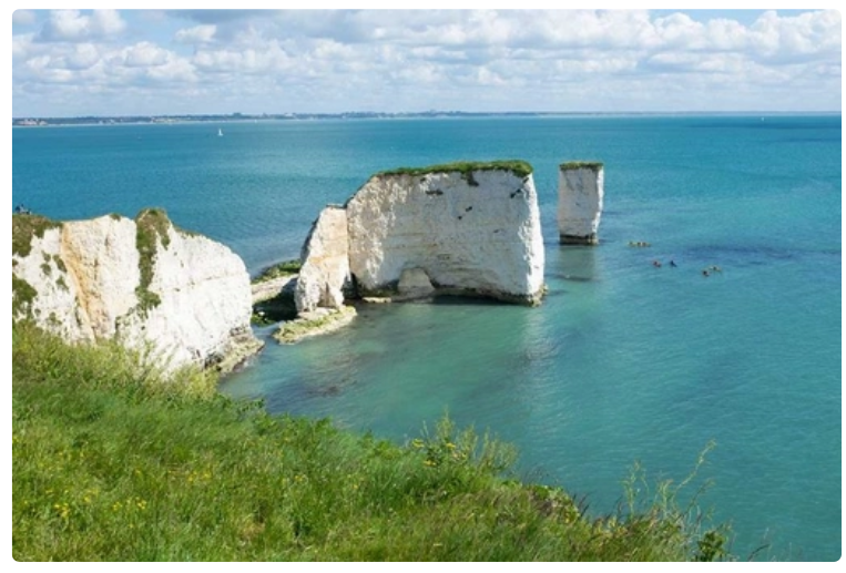 <p>Old Harry’s Rocks, Dorset, England</p><p>The chalk of Old Harry Rocks used to be part of a long stretch of chalk between Purbeck and the Isle of Wight, but remained as a headland after large parts of this seam were eroded away. </p><p>Hydraulic action towards to headland resulting in enlarging cracks, then caves, then arches.  The arches collapsed after being weakened by rainfall and wind, leaving disconnected stacks. </p><p>One of these stack’s is known as Old Harry, and Old Harry’s wife was another stack which has now become a stump due to corrosion. Hydraulic action then eroded the stump away.</p>