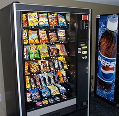 <p>(n.phrv) mua cái gì từ máy bán hàng tự động</p><p>The _________ offers snacks and drinks for purchase.</p>