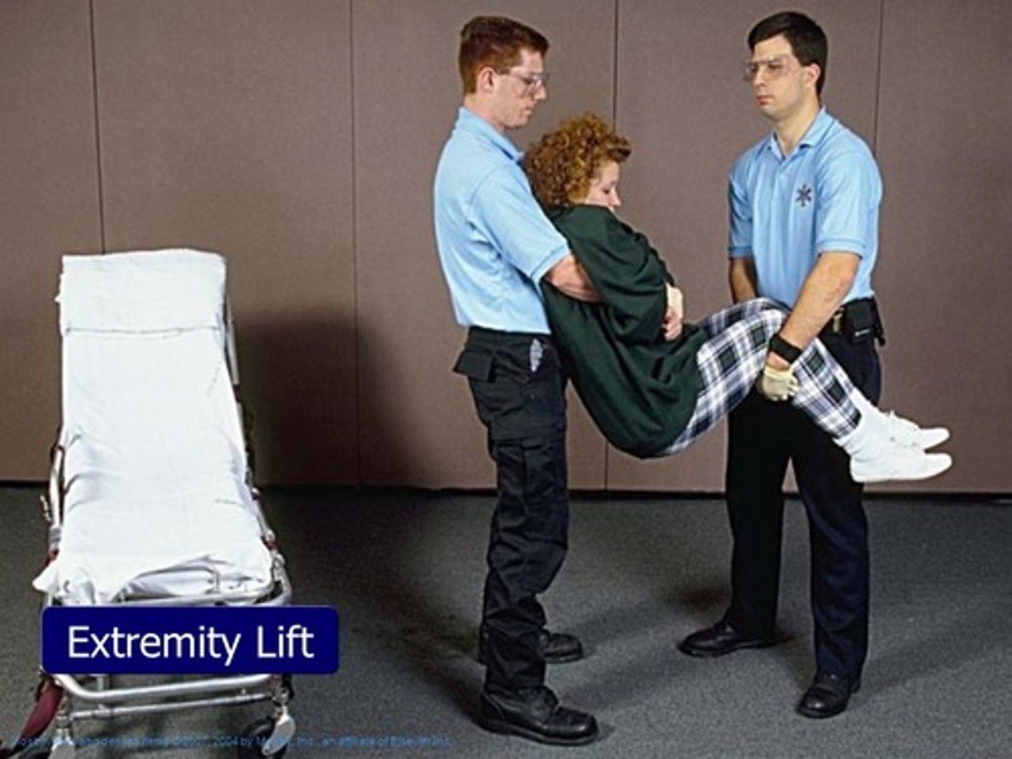 <p>Cross patients arms in front of the patient and come from back grabbing the patient's wrists. You can add someone to hold the feet.</p>