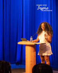 <p>She is presenting at a podium.</p>