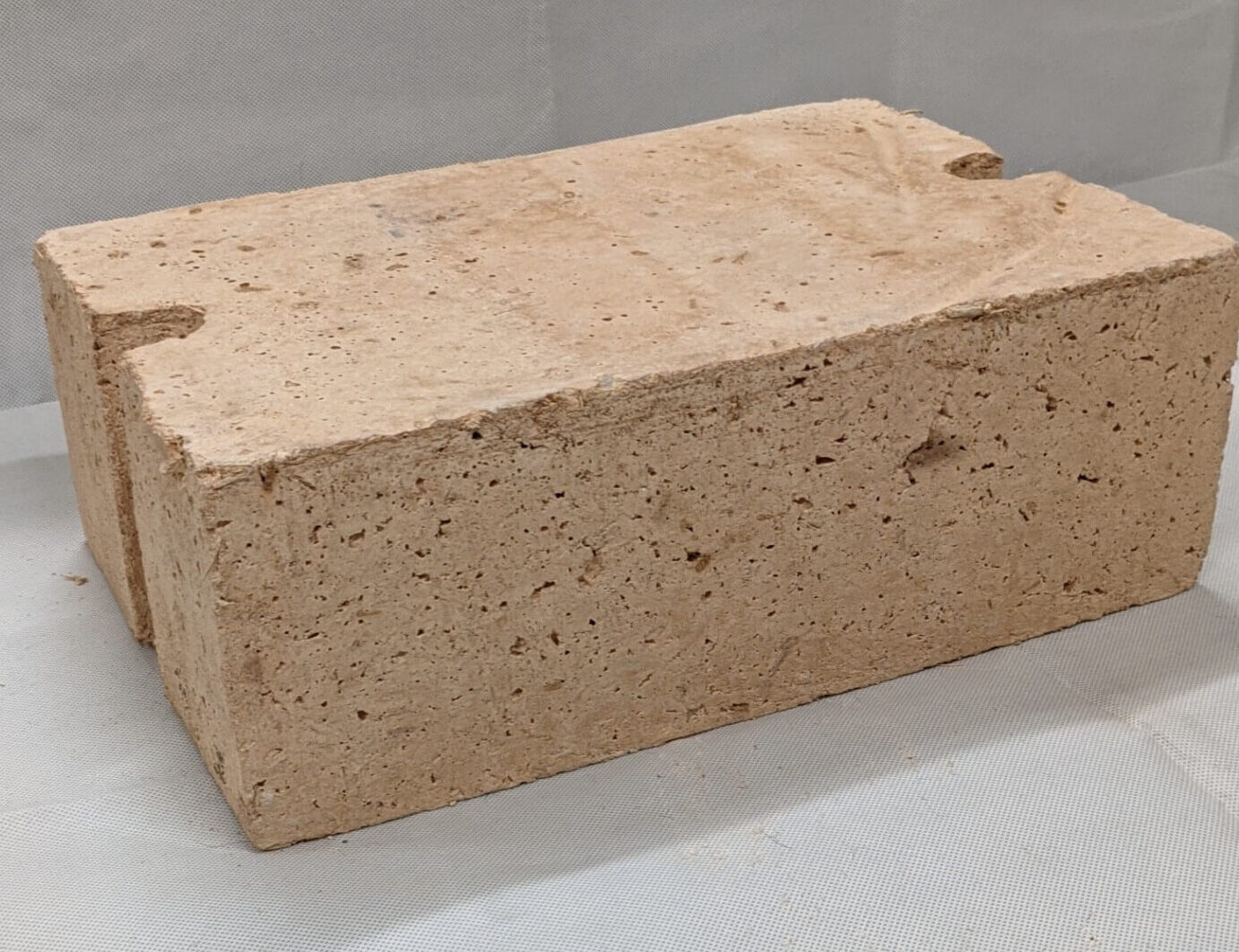 <p>An ancient, air-dried building block made from a mixture of earth (clay, sand, and silt), water, and a binding fiber like straw or rice husks. Also commonly known as adobe, the mixture is packed into molds and sun-baked rather than fired in a kiln. (ex: Ziggurat)</p>