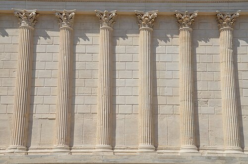 <p>a column embedded in a wall and partly projecting from the surface of the wall, sometimes defined as semi- or three-quarter detached</p>