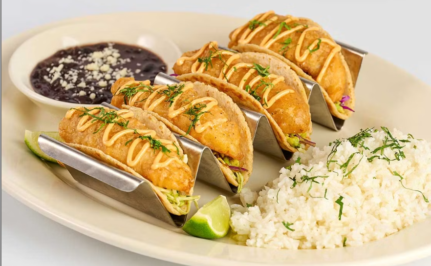 <p>Soft Corn Tortillas Filled with Grilled Fish or Crispy Hand Battered Fish, Avocado, Tomato, Chipotle Sauce, Marinated Onions and Cilantro. Served with Rice and Beans</p>