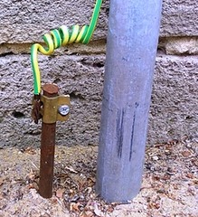 <p>The removal of excess charge by providing a low resistance path for electrons to flow through.</p>