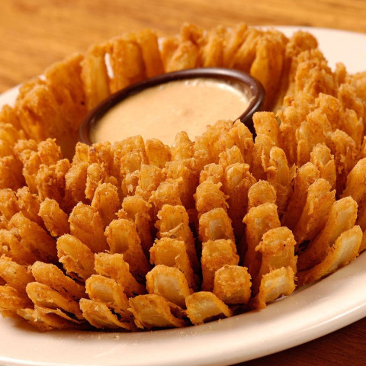 <p>A colossal onion, breaded and fried, served with spicy mayo, and horseradish sauce.</p><p>Note: Served with "on another level" pedestal.</p>