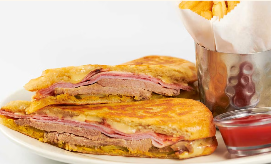 <p>Slow Roasted Pork, Ham, Swiss Cheese, Pickles, Mustard and Mayonnaise on a Grilled and Pressed Roll</p>